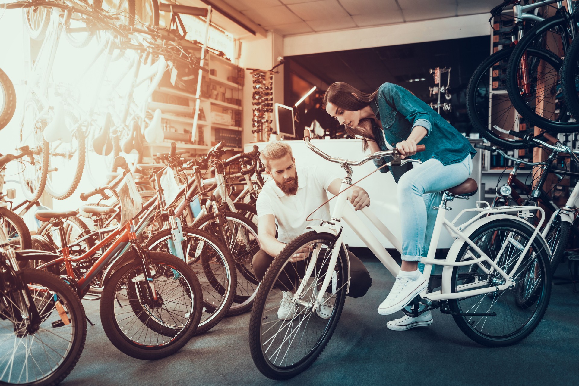Girl Chooses City Bike with Seller in Sport Store